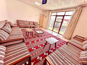 a room with couches and rugs on the floor at Labella Chalet in Barka