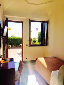 a bedroom with a bed and a desk and a window at Don Felipe Boutique Hotel in Ischia Town