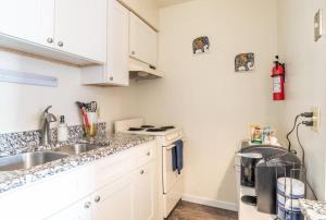 a kitchen with white cabinets and a sink at Karma Vibe Like That in Bloomington