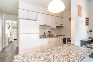 a kitchen with white cabinets and a marble counter top at Karma Vibe Like That in Bloomington