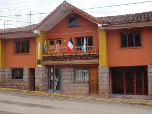 un edificio con banderas delante en Hospedaje Encanto de Chinchero en Chincheros