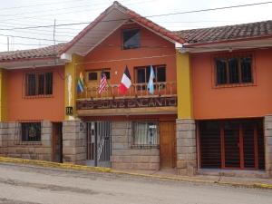 a building with flags in front of it at Hospedaje Encanto de Chinchero in Chincheros