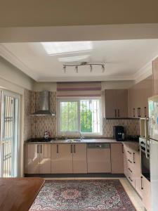 a kitchen with white cabinets and a large window at Villa Mango in Fethiye