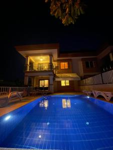 a swimming pool in front of a house at night at Villa Mango in Fethiye