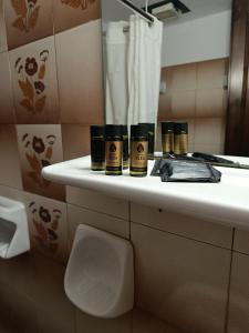 a bathroom with a shelf with three products on it at Pegasus Hotel in Pythagoreio +35 photos
