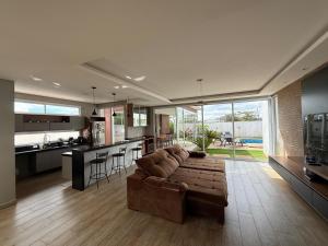 a large living room with a couch and a kitchen at Recanto da Bella in Paranapanema
