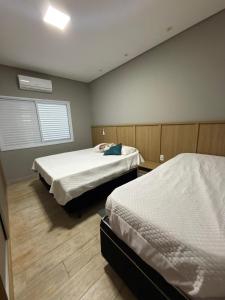 a room with two beds and a window in it at Recanto da Bella in Paranapanema