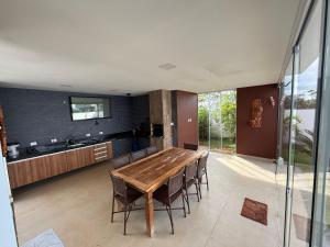 a kitchen and dining room with a wooden table and chairs at Recanto da Bella in Paranapanema