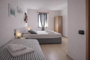 a bedroom with two beds and a window at Albergo Garnì Casa del Lago in Tenno