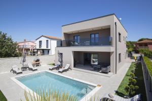 a villa with a swimming pool and a house at Villa Del Sol near Fažana in Valbandon