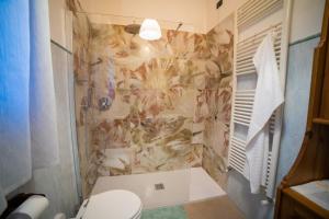a bathroom with a toilet and a tile wall at LUCIA s sweet Home in Padova +8 photos