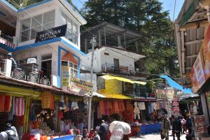 a group of people walking through a market with shops at Devdaar Cottage Gangotri in Gangotri