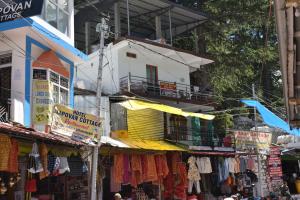 a group of shops in a street with a building at Devdaar Cottage Gangotri in Gangotri