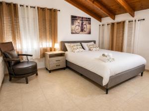a bedroom with a large bed and a chair at המקום של ברקו in Me‘ona +32 photos