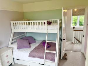 a bedroom with two bunk beds with purple pillows at The Cornish Retreat in Bude