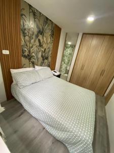 a bedroom with a bed with a checked bedspread at Apartaestudio vacacional in Armenia
