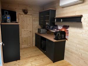 a kitchen with black cabinets and a fire in the wall at Tinyhaus auf dem Forsthof in Trinwillershagen