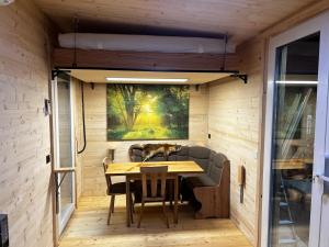 a tiny house with a table and chairs at Tinyhaus auf dem Forsthof in Trinwillershagen +7 photos