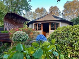 a small house in a garden with flowers at Pumula Luxury Camps in Lions River