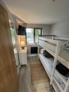 a bedroom with two bunk beds and a window at Riverside Lodge in Creech Saint Michael
