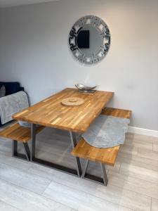 a wooden table with a bench and a mirror at Riverside Lodge in Creech Saint Michael