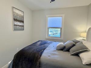 a bedroom with a bed with pillows and a window at Oceanfront Cottage on Private Island in Milbridge +35 photos