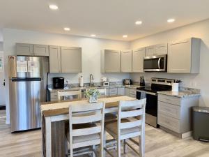 a kitchen with white cabinets and a table with chairs at Oceanfront Cottage on Private Island in Milbridge