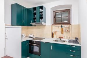a kitchen with green cabinets and a sink at Casa del Sol in Strp