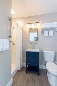 a bathroom with a toilet sink and a mirror at Bar Harbor Villager Motel - Downtown in Bar Harbor +12 photos