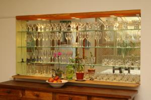 una vitrina de cristal llena de vasos y un bol de fruta en As Nancy B&B en Ushuaia