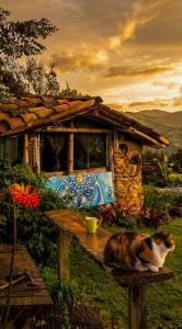 a cat sitting on a table in front of a house at Aldea Victoria EcoRefugio in Medellín