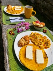 a table with plates of food and a cup of coffee at Aldea Victoria EcoRefugio in Medellín