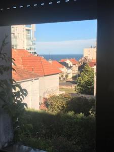 una ventana con vistas a las casas con techos rojos en Mar Del Plata Playa Grande en Mar del Plata