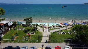 a beach with a park with umbrellas and a playground at Hotel Vila Mar in Florianópolis
