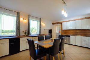 a large kitchen with a table and chairs in it at Anna Vendégház Szeleste in Szeleste +24 photos
