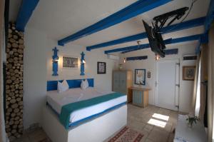 a blue and white bedroom with a bed and a television at Pension Sharaiman in Dunavăţu de Jos +40 photos