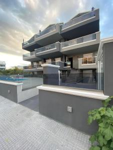 a large building with a swimming pool in front of it at BmB apartments in Paralia Katerinis