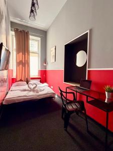 a bedroom with a bed and a desk with a laptop at Royal Aparthotel Piotrkowska 116 in Łódź