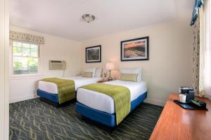 a hotel room with two beds and a window at Bar Harbor Villager Motel - Downtown in Bar Harbor