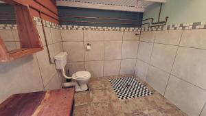 a bathroom with a white toilet in a room at Zuri Camp - Tent Kiama in Tsumeb