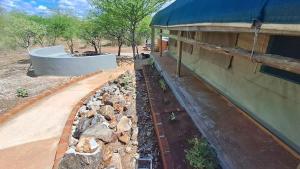 a retaining wall next to a building with a tub at Zuri Camp - Tent Kiama in Tsumeb