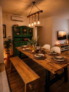 a wooden table with plates and wine glasses on it at Cozy flat near park in Netanya