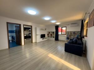 a living room with a black couch and wooden floors at Casa Maia Corbu in Corbu +18 photos