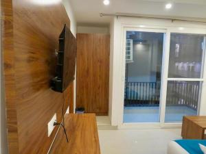a living room with a tv and a sliding glass door at Boho Stays Rishikesh in Rishīkesh