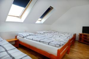 two beds in a room with two windows at Anna Vendégház Szeleste in Szeleste