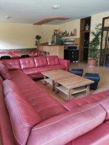 a large red leather couch with a wooden table at ChataKováčová in Kováčová