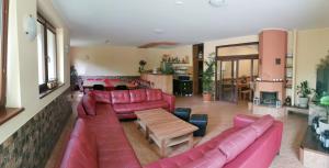 a living room with red leather couches and a table at ChataKováčová in Kováčová