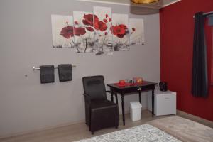 a room with a table and a chair and flowers on the wall at Chez Martine et Jean-Marc in Tintigny