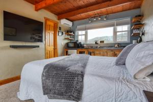 a bedroom with a large bed and a kitchen at Sunrise Cabin at Highland Meadows - King Bed and Views in Hot Springs