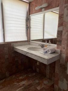 a bathroom with a sink and a mirror at Galeria Elementos, Tierra in Campeche